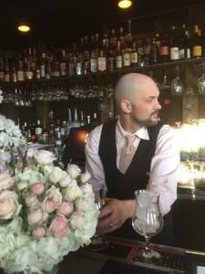 Pink-clad mixologist shaking things up in front of the blossoms